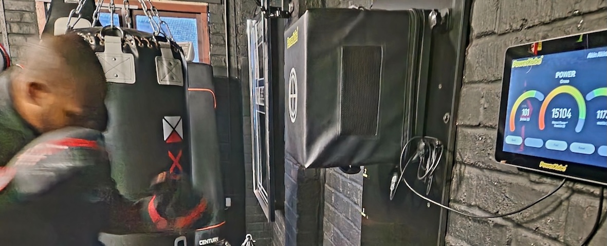 Boxing Fitness MK gym interior showing multiple punching bags and PowerKube equipment