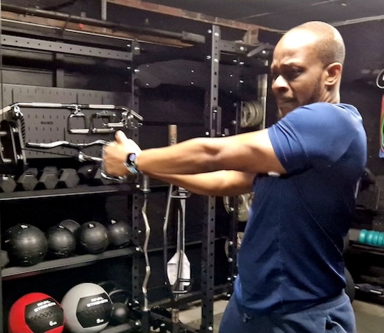 Man performing cable machine workout for strength training at Boxing Fitness MK gym